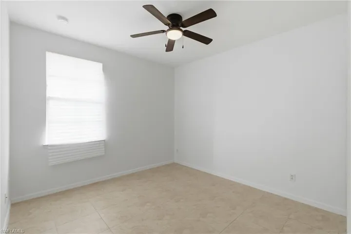 Empty room with baseboards and a ceiling fan