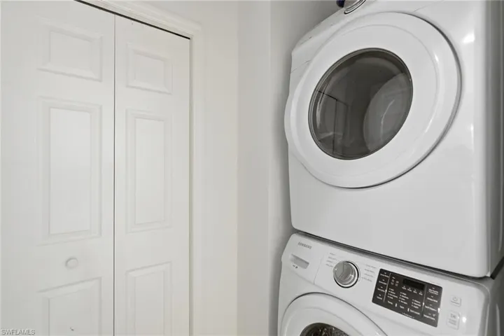 Laundry area with stacked washer and dryer