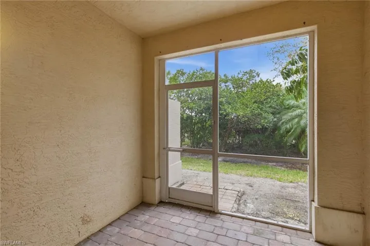 Doorway with brick floors and a textured wall