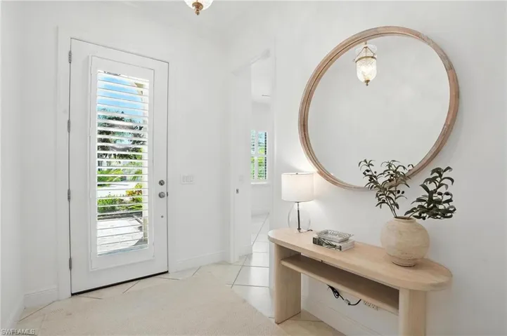 Foyer with crown molding and light tile patterned flooring