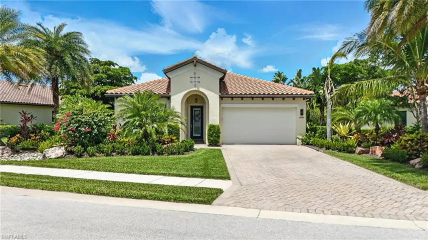 Mediterranean / spanish house with stucco siding, a tile roof, an attached garage, and driveway