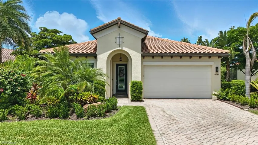 Mediterranean / spanish-style home with stucco siding, a tile roof, a garage, and driveway