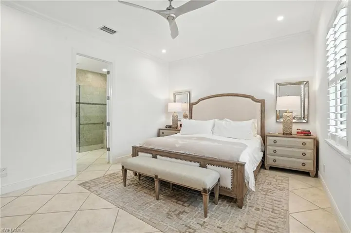 Bedroom featuring light tile patterned flooring, crown molding, a ceiling fan, recessed lighting, and connected bathroom
