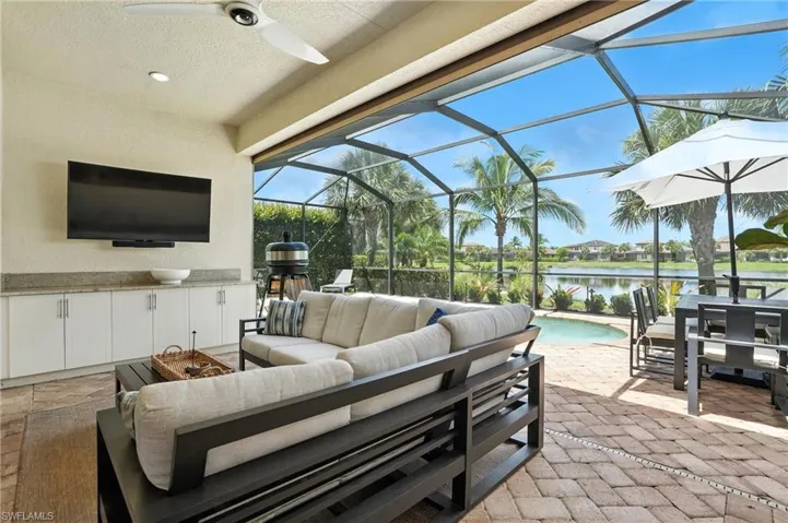 View of patio / terrace featuring outdoor lounge area, area for grilling, ceiling fan, an outdoor pool, and a water view