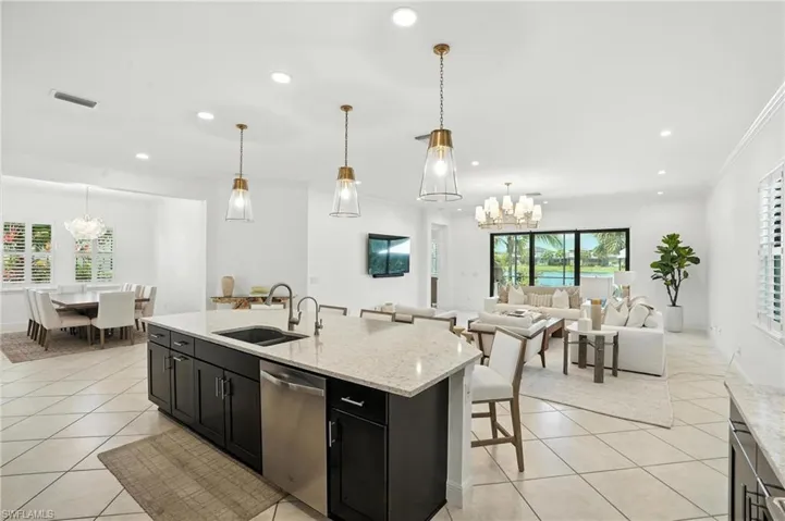 Kitchen featuring stainless steel dishwasher, a chandelier, dark cabinetry, light tile patterned floors, and recessed lighting