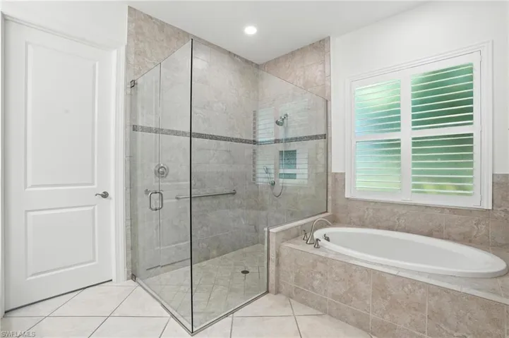 Full bathroom with a garden tub, a shower stall, and tile patterned flooring