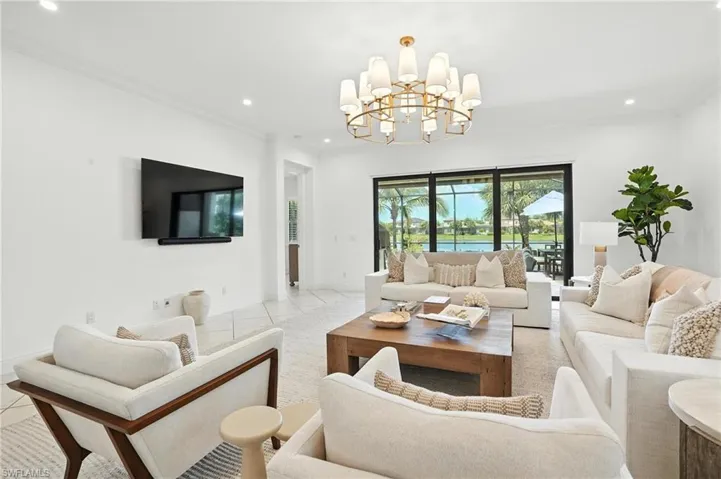 Living room featuring a chandelier, recessed lighting, light tile patterned floors, and crown molding