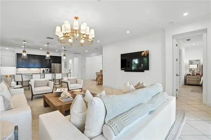 Living room featuring light tile patterned floors, recessed lighting, a chandelier, and crown molding