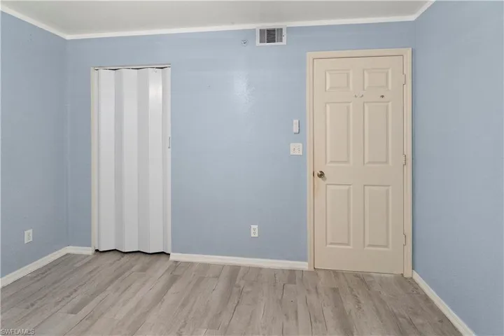 Unfurnished room featuring wood finished floors and crown molding