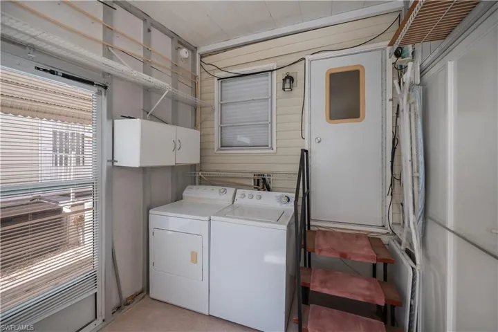 Laundry room with washer and clothes dryer and cabinet space