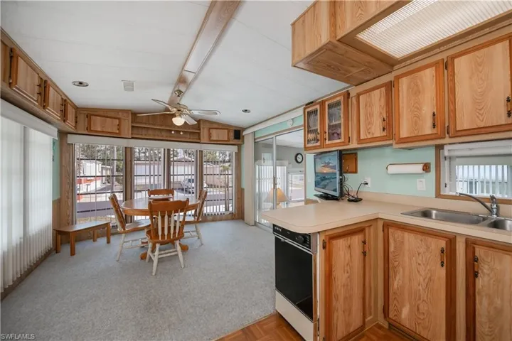 Kitchen featuring a ceiling fan, a sink, lofted ceiling with beams, and a wealth of natural light