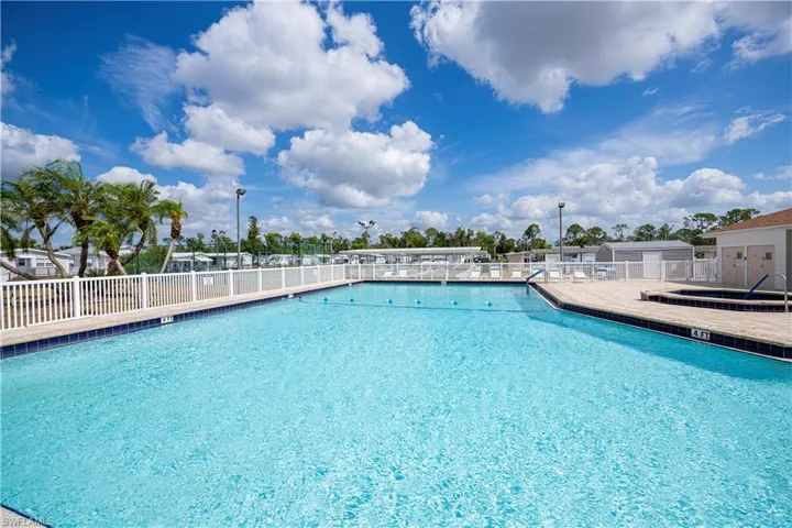 Community pool featuring fence and a patio area