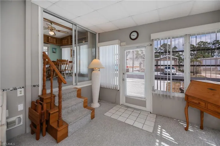 Entryway featuring visible vents, carpet flooring, a ceiling fan, and a wealth of natural light