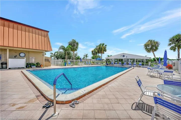 Community pool featuring fence and a patio
