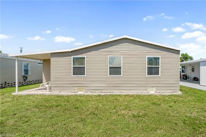 Rear view of property with a patio area and a lawn