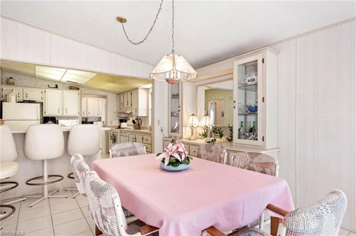 Dining space featuring light tile patterned floors and lofted ceiling
