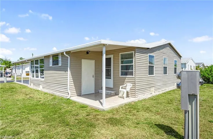 View of front of property with a front yard and a patio area