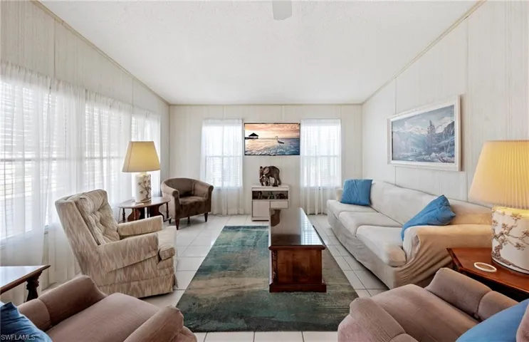 Tiled living room with crown molding and a textured ceiling