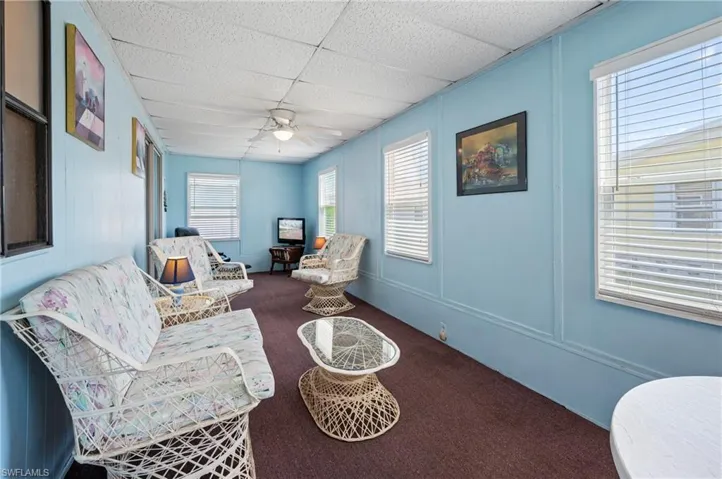 Sitting room with a paneled ceiling, ceiling fan, and carpet floors