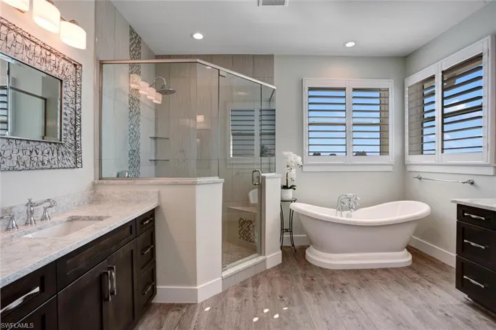 Master bathroom with walk-in shower, soaking tub, and his/hers vanities