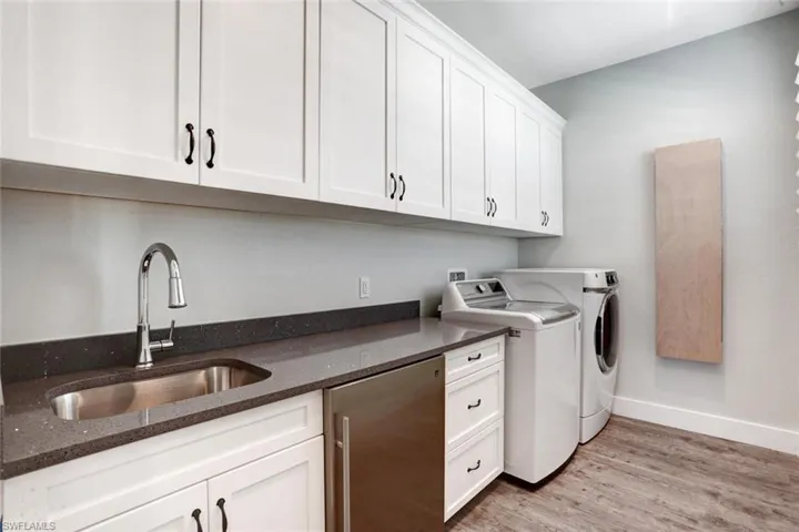 Third-level laundry room with mini refrigerator and plenty of work space