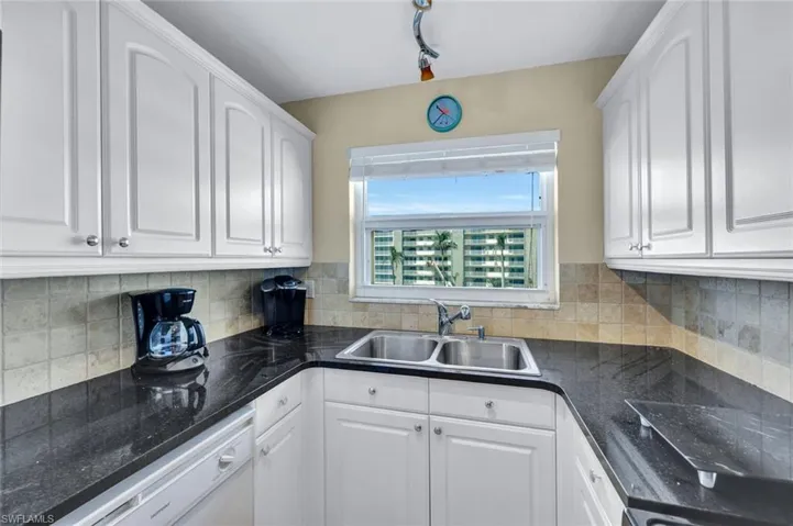 Kitchen with sink, white cabinets, and white dishwasher