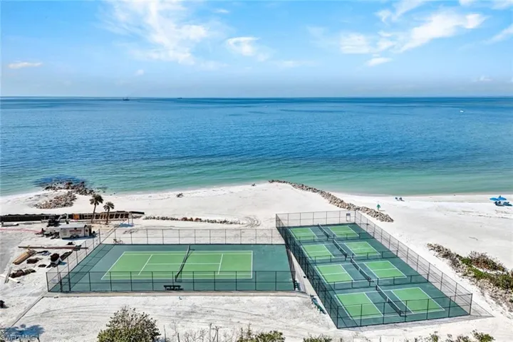 Birds eye view of property featuring a water view and a view of the beach