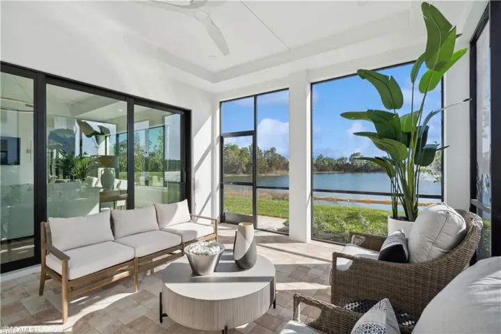 Sunroom with ceiling fan and a water view