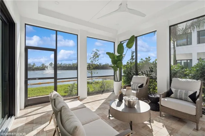 Sunroom / solarium featuring a water view and ceiling fan