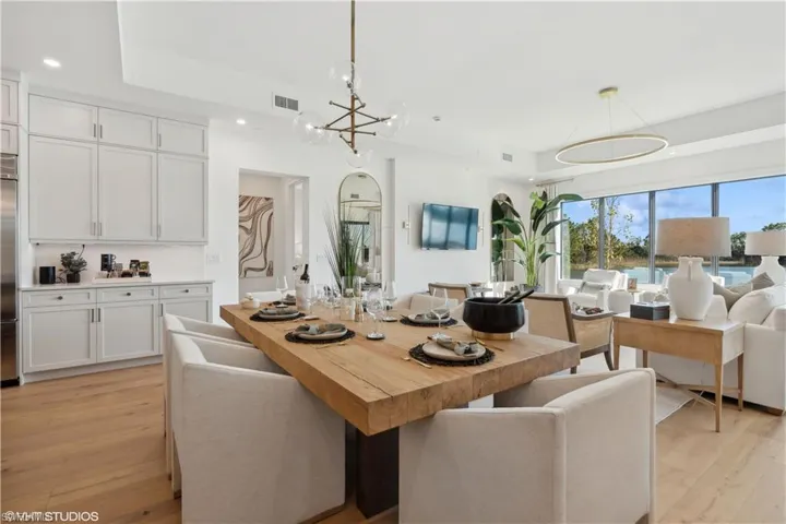 Dining space with light hardwood / wood-style flooring and a chandelier