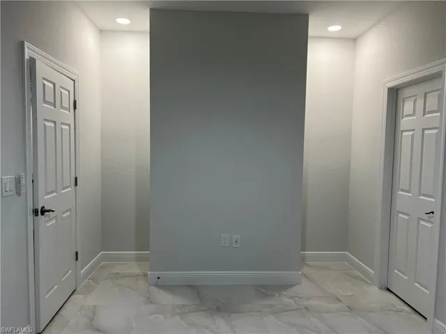 Empty room with baseboards, marble finish floor, and recessed lighting