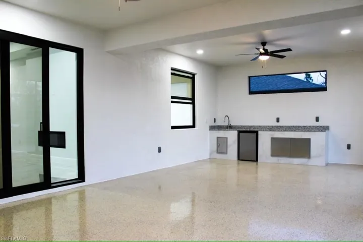 Unfurnished lanai with speckled floor, recessed lighting, and a ceiling fan