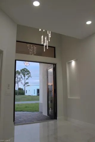 Entryway featuring marble finish floor, baseboards, and recessed lighting