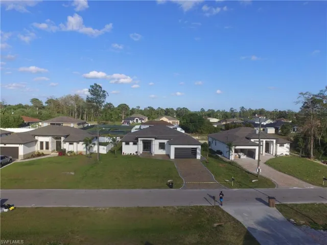 View of front of house featuring a residential view, driveway, a front yard, and an attached garage