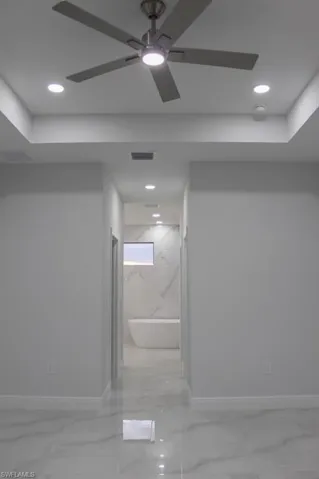 Master bed room with baseboards, marble finish floor, visible vents, and a ceiling fan