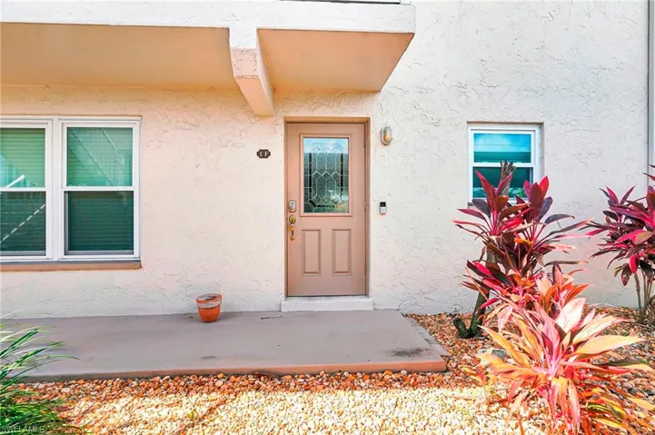 View of exterior entry with stucco siding and a patio area