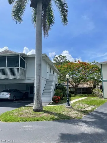 UNIT #1 IS AROUND BACK. THIS IS THE SIDE YARD WITH BEAUTIFUL ROYAL POINCIANA TREE