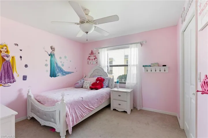 Bedroom featuring light carpet, a ceiling fan, and a closet