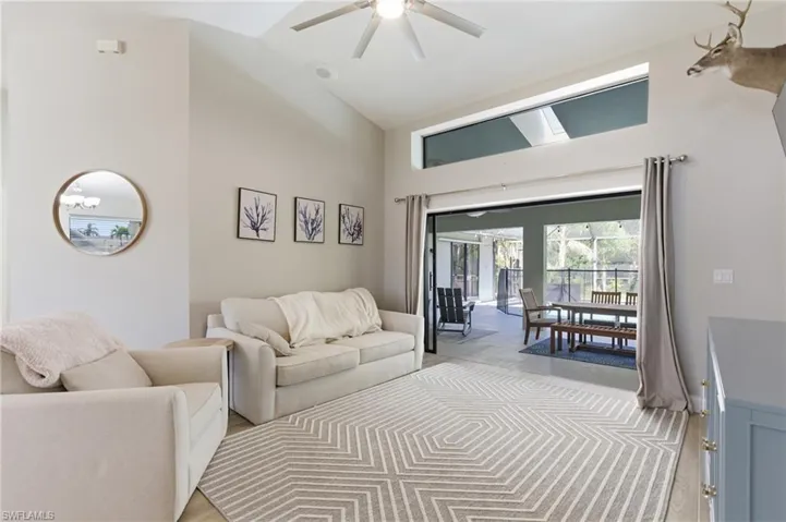 Living area featuring a skylight, ceiling fan, and vaulted ceiling