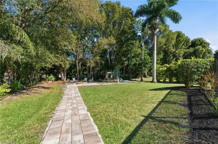 View of home's community featuring a playground and view of scattered trees
