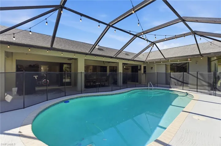 View of swimming pool featuring a lanai, a sunroom, and patio surround