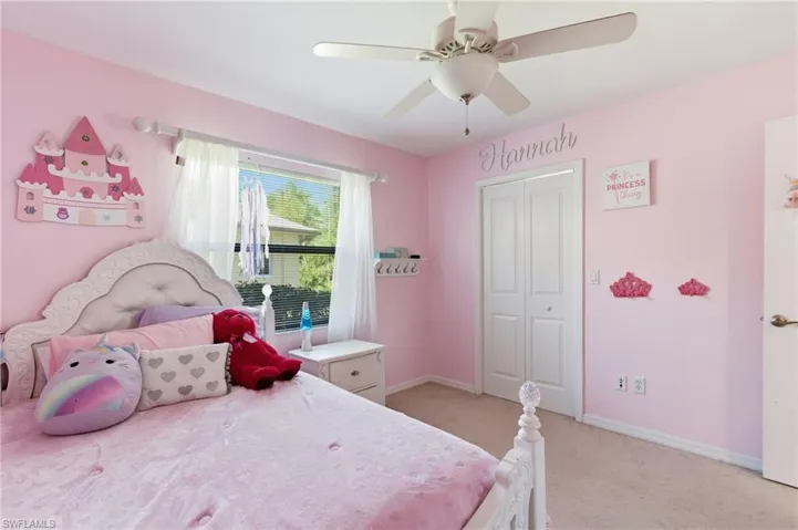 Bedroom featuring light carpet, a ceiling fan, and a closet