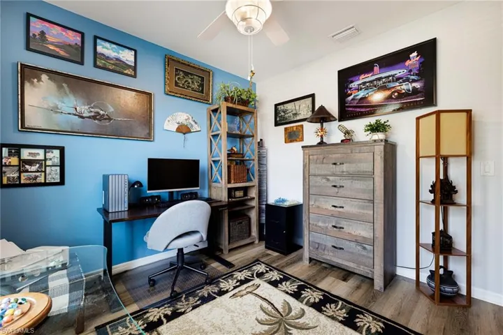 Office with wood finished floors and ceiling fan