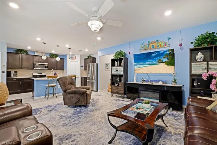 Living room featuring a ceiling fan, recessed lighting, and light tile patterned flooring