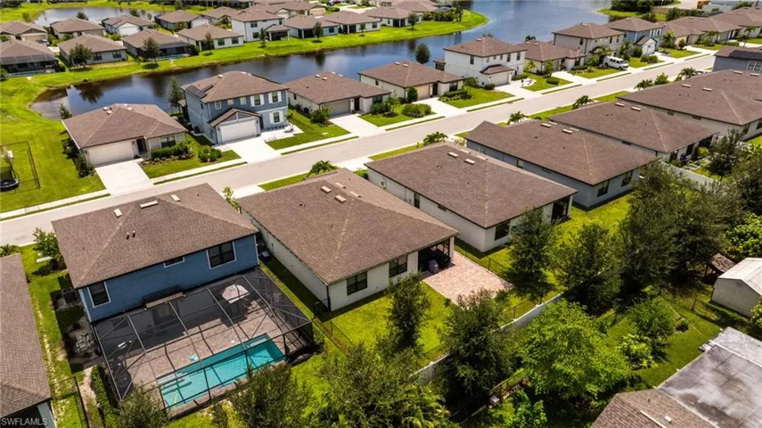 Aerial perspective of suburban area featuring a nearby body of water