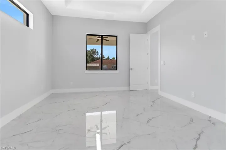 Empty room with ceiling fan and a wealth of natural light