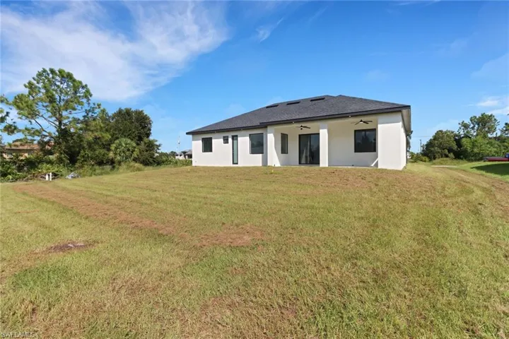 Back of house featuring a yard