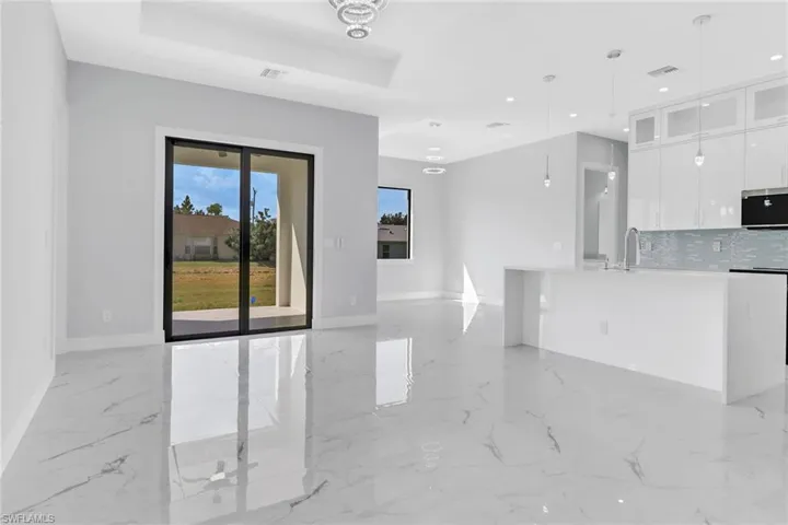 Unfurnished living room featuring a raised ceiling
