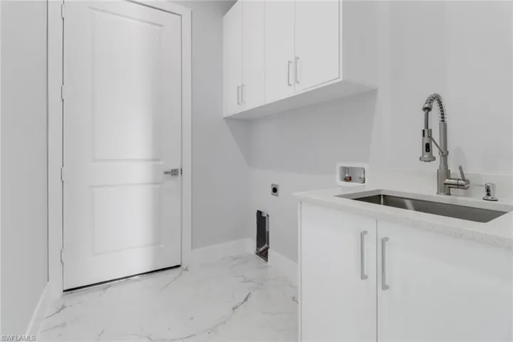 Laundry room featuring cabinets, hookup for an electric dryer, washer hookup, and sink