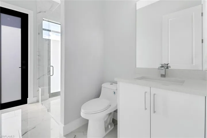 Bathroom with walk in shower, vanity, and toilet